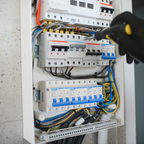 Close-up of electrician working on circuitry.
