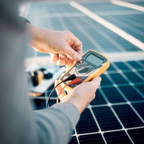 Solar panels, multimeter and engineering hands for voltage check, installation or maintenance. Sust.