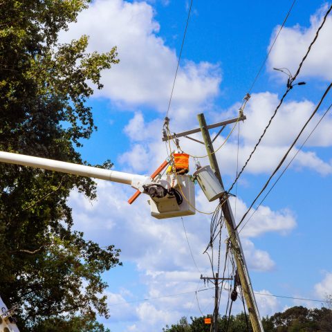 There is power outage following severe violent hurricane that damaged power line that has to be repaired by emergency workers